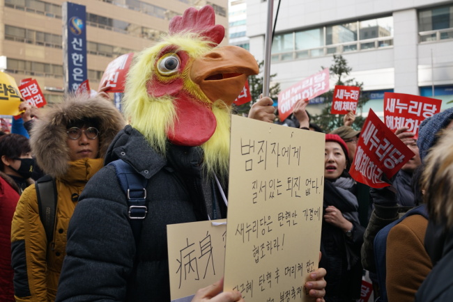 A protester wears a chicken costume to make fun of President Park while marching towards the presidential office. (Bak Se-hwan/The Korea Herald)