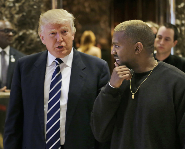 President-elect Donald Trump talks with Kanye West in the lobby of Trump Tower in New York, Tuesday. (AP - Yonhap)