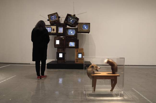 A woman looks at the “Allan and Allen” installation by Nam June Paik as she stands next to the “Wolf Table” installation by artist Victor Brauner at the living room section of the “No Place Like Home” exhibition in the Israel Museum in Jerusalem on Sunday. (AFP-Yonhap)