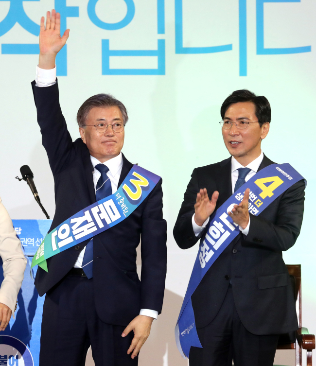 Presidential front-runner Moon Jae-in (left), beside his rival An Hee-jung, celebrates after winning the second primary race in Daejeon, Wednesday. (Yonhap)