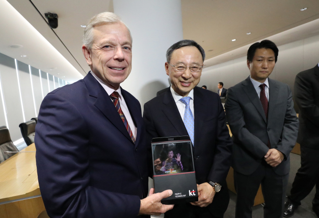 Verizon CEO Lowell McAdam (left) and KT CEO Hwang Chang-gyu demonstrate a hologram video call via a tablet PC at the KT headquarters in Gwanghwamun, central Seoul, on Monday. (KT)