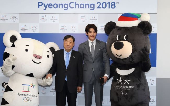 Actor Kim Woo-bin, second from right, poses with Lee Hee-beom, head of the PyeongChang Organizing Committee, at the signing ceremony held at the POC office in PyeongChang, Gangwon Province, on Thursday afternoon. (PyeongChang Organizing Committee)