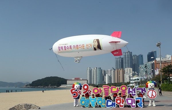 Officials of the National Election Commission fly an airship with a banner campaigning for votes in the May 9 presidential election at Haeundae Beach, in Busan, Thursday. (Yonhap)