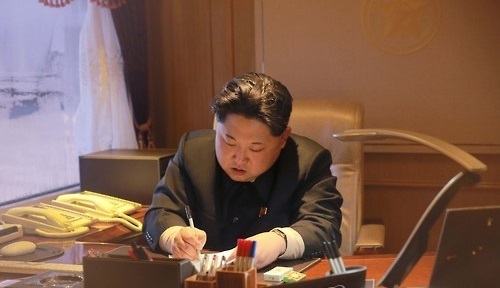 North Korean leader Kim Jong-un signs an order on the previous day to launch the 