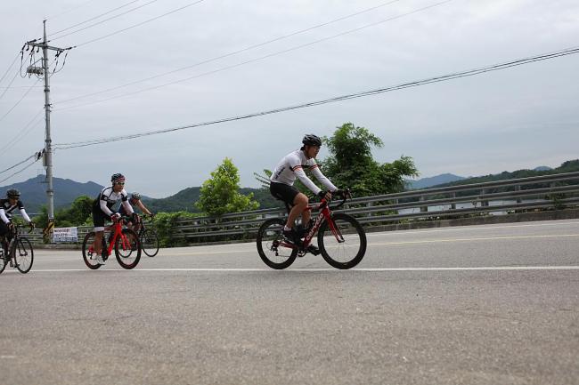 Members of a cycling club climb the incline of a road in Gyeonggi Province. (Bak Se-hwan/The Korea Herald)