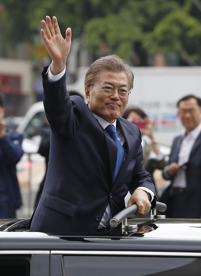 President Moon Jae-in waves as he pass by citizens in Gwanghwamun Square, central Seoul on Wednesday.(Yonhap)