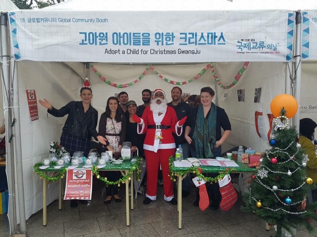 Sarah Elizabeth Hale (right) stands with other volunteers at the Adopt-a-Child for Christmas booth during Gwangju International Community Day in October. 