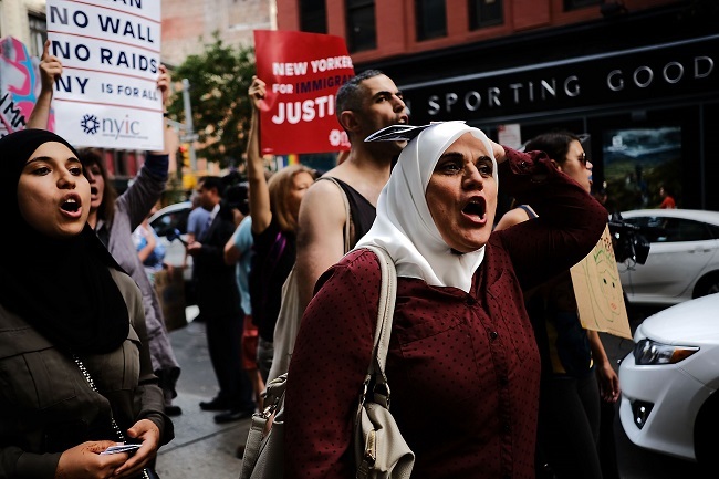 Immingrants join activists for an evening protest in Manhattan hours before a revised version of President Donald Trump`s travel ban that was approved by the Supreme Court is to take effect on June 29, 2017 in New York City. (AFP-Yonhap)