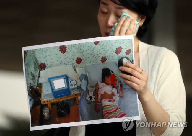 Plaintiff Choi Eun-ju holds a picture of her daughter in front of Seoul District Prosecutors Office on Wednesday. (Yonhap)