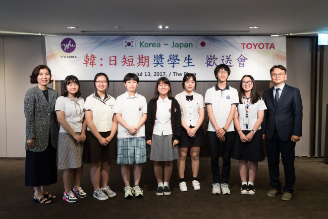 In Sung-yeon (left), assistant national director of the Youth for Understanding Korea, and Choi Tae-yeong (right), general manager of Toyota Korea, pose with seven Korean students who will participate in a monthlong exchange program in Japan under the sponsorship of the Japanese auto company. The sendoff event was held at the Plaza Hotel in Seoul on Thursday (YFU Korea)