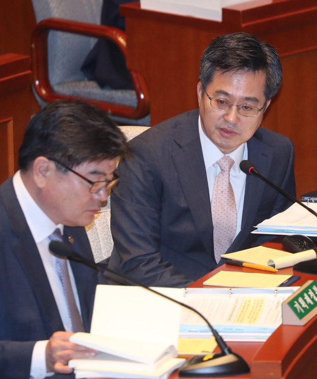 Deputy Prime Minister for Economic Affairs and Finance Minister Kim Dong-yeon (right) sits in a parliamentary budget committee meeting Tuesday. (Yonhap)