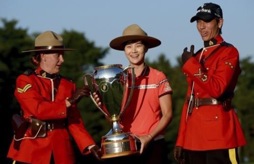 Park Sung-hyun of South Korea (C) is flanked by a pair of Canadian Mounties after winning the Canadian Pacific Women`s Open on the LPGA Tour in Ottawa on Aug. 27, 2017. (AP-Yonhap)