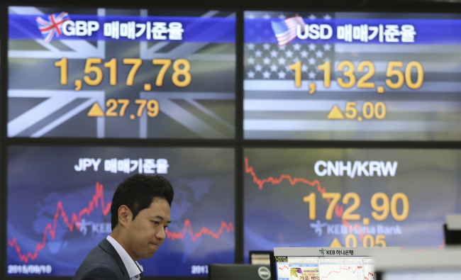 A currency trader watches monitors at the foreign exchange dealing room of the KEB Hana Bank headquarters in Seoul on Friday. (AP-Yonhap)