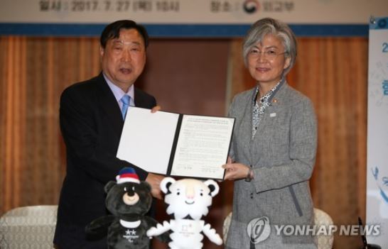 This file photo shows Foreign Minister Kang Kyung-wha (R) posing with Lee Hee-beom, the chief organizer of the PyeongChang Winter Games, after signing an agreement for cooperation in July. (Yonhap)