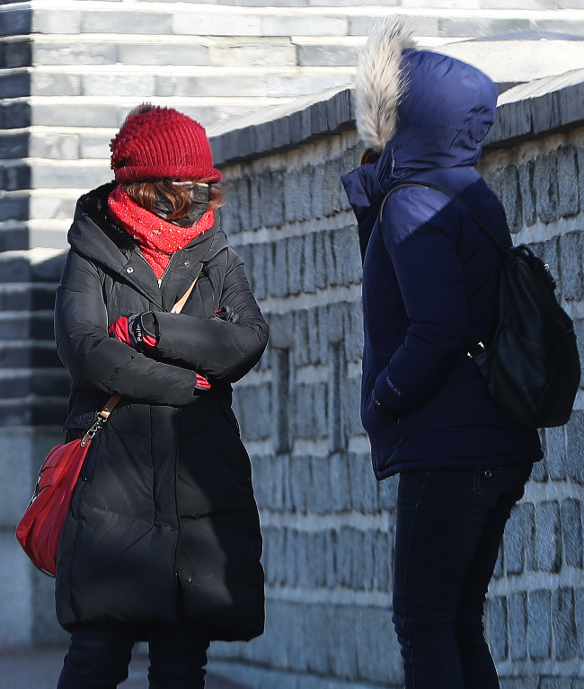 People are seen bundled up in warm clothes in Suwon, Gyeonggi Province, on Monday morning, as the season’s strongest cold snap sent the mercury down to as low as around minus 10 degrees in inland areas. (Yonhap)