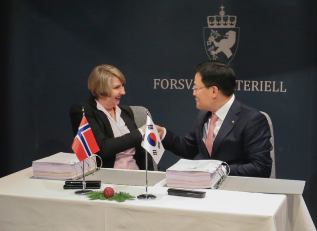 Son Jae-il, Hanwha Land Systems CEO, shakes hands with Mette Elin Sørfonden, head of Norway's defense material agency, after a contract on K9 self-propelled howitzers. (Hanwha Group)