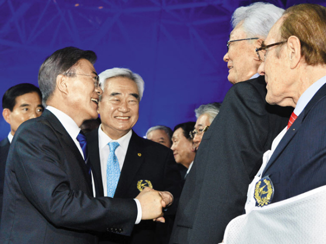 President Moon Jae-in (left) shakes hands with North Korean IOC member Chang Ung at the opening ceremony of the World Taekwondo Championships in Muju, North Jeolla Province, in June 2017. (Yonhap)