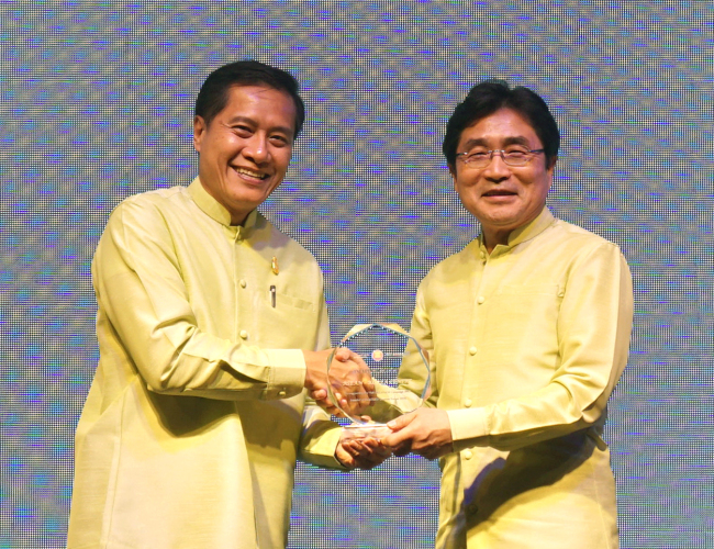 ASEAN-Korea Center Secretary-General Kim Young-sun (right) receives an award from Thai Minister of Tourism and Sports Weerasak Kowsurat for enhancing bilateral tourism at the 37th ASEAN Tourism Forum in Chiang Mai, Thailand, Friday. (ASEAN-Korea Center)