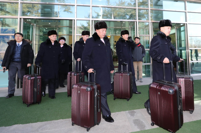 Twenty-three members of the advance team for North Korea‘s art performances in the South board a bus in Paju, Gyeonggi Province, on Monday after crossing the border. (Joint Press Corps - Yonhap)