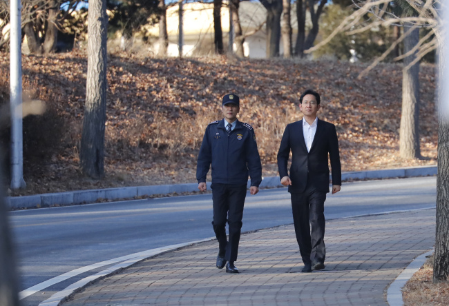 Samsung heir Lee Jae-yong (right) leaves the Seoul Detention House in Uiwang, Gyeonggi Province, on Monday as he was set free in an appeals trial. (Yonhap)