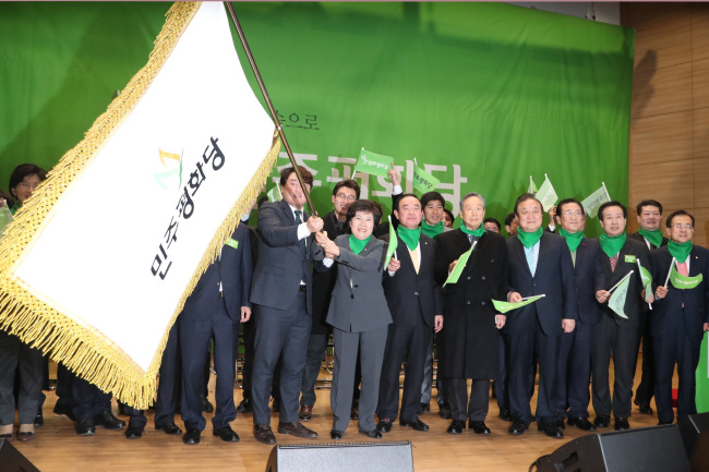 Cho Bae-sook, the leader of the new Party for Democracy and Peace, waves the party`s flag during a convention marking its creation at the National Assembly in Seoul on Tuesday. (Yonhap)