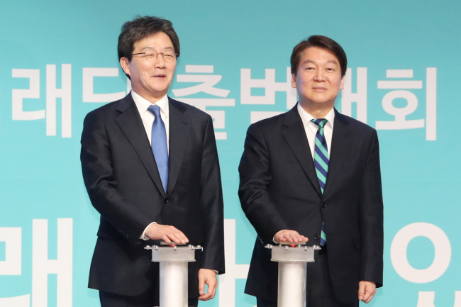 Yoo Seong-min (L), co-leader of the Bareun Future Party and Ahn Cheol-soo, former leader of the People`s Party each press a button signaling the launch of the new centrist party on Tuesday. (Yonhap)