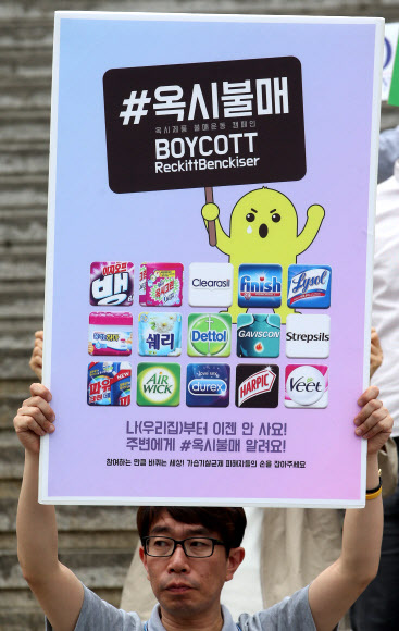 A man holds a picket in Seoul calling for a boycott of Reckitt Benckiser products.