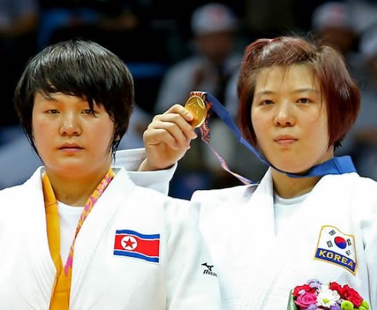 In this file photo taken on Sept. 22, 2014, South Korea`s Jeong Gyeong-mi (right) shows her gold medal after beating North Korea`s Sol Kyong in the women`s under-78-kilogram judo event at the Asian Games in Incheon. (Yonhap)