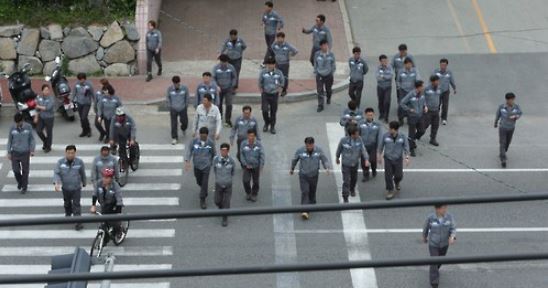 This undated file photo shows workers coming out of their workplace for lunch. (Yonhap)