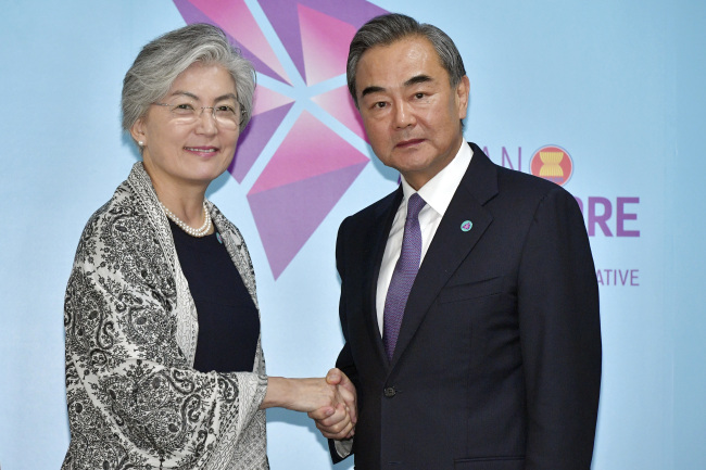 China`s Foreign Minister Wang Yi, right, and South Korea`s Foreign Minister Kang Kyung-wha pose for a photo ahead of a bilateral meeting on the sidelines of the 51st ASEAN Foreign Ministers Meeting in Singapore, Friday, Aug. 3. (AP-Yonhap)