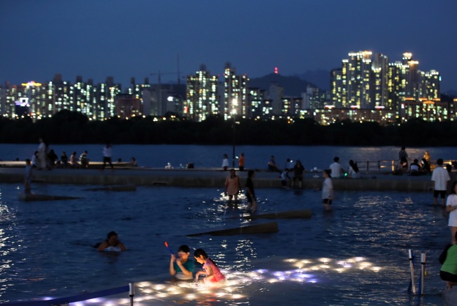 Seoul residents spend time by the Han River at night amid the ongoing heat wave. (Yonhap)