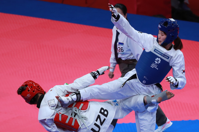 South Korea`s Kim Jan-di lands a kick on opponent Nigora Tursunkulova of Uzbekistan in the semi-final round on Monday. Yonhap