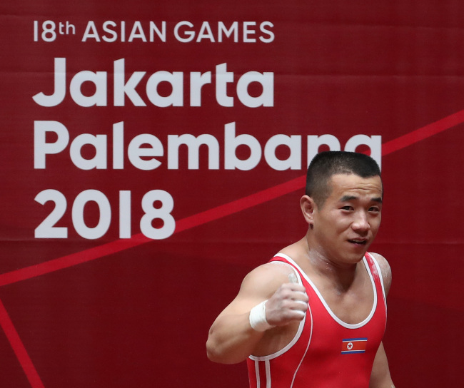 North Korean weightlifter Om Yun-chol pumps a fist after a successful lift at the Jakarta-Palembang Asian Games on Monday. Yonhap
