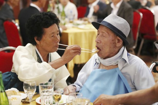 North Korean Ahn Jong Sun, 70, left, feeds her South Korean father Ahn Jong-ho, 100, during a dinner at the Diamond Mountain resort in North Korea, Monday, Aug. 20. (AP)