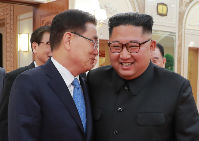 Chung Eui-yong, head of the presidential National Security Office (left) talks to North Korean leader Kim Jong-un (right) in Pyongyang on Wednesday. (Yonhap)
