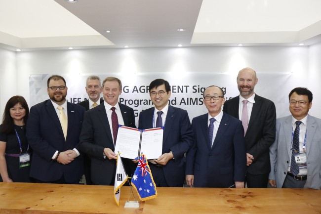 LIG Nex1 CEO Kim Ji-chan (fifth from left) and Rob Hawkets (fourth from left), vice president of KBR Government Services Asia Pacific, pose at a signing ceremony during the industry exhibition DX-Korea 2018 at Kintex in Goyang, Gyeonggi Province, Thursday. (LIG Nex1)