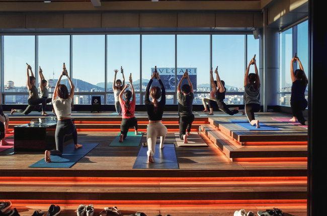 Participants practice the sun salutation pose with a beer in their hands during a beer yoga lass. (Almondon)