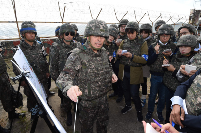 An Army general commanding the demining operation briefs reporters about the location of buried mines and the procedure to search for them. Yonhap