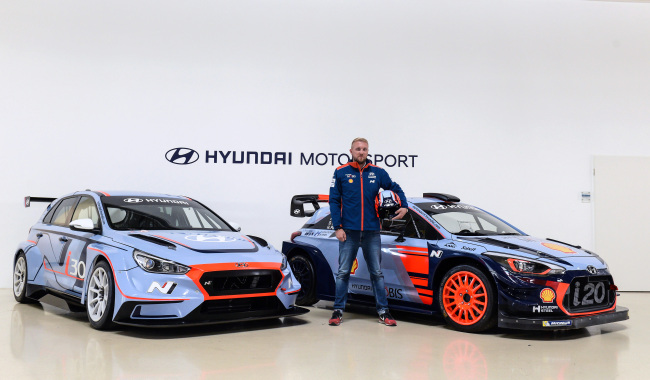 A racer poses between the i30 N TCR (left) and i20 Coupe WRC.