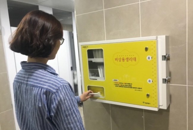 A woman uses a feminine hygiene vending machine that provides free women`s products at a public facility in Seoul. (Seoul Metropolitan Government)