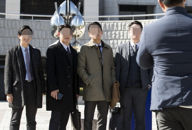 South Korean members of Jehovah`s Witnesses pose for photos in front of the Supreme Court in Seoul on Thursday, after the top court ruled that religious beliefs are to be considered as valid reasons for refusing the country’s mandatory military service. (Yonhap)