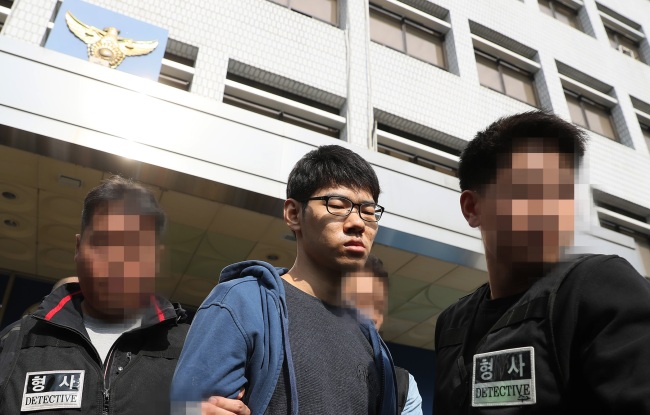 Kim Seong-su, a suspect in the murder of an Internet cafe employee in Seoul last month, is led out of Yangcheon Police Station in Seoul on Oct. 22. (Yonhap)