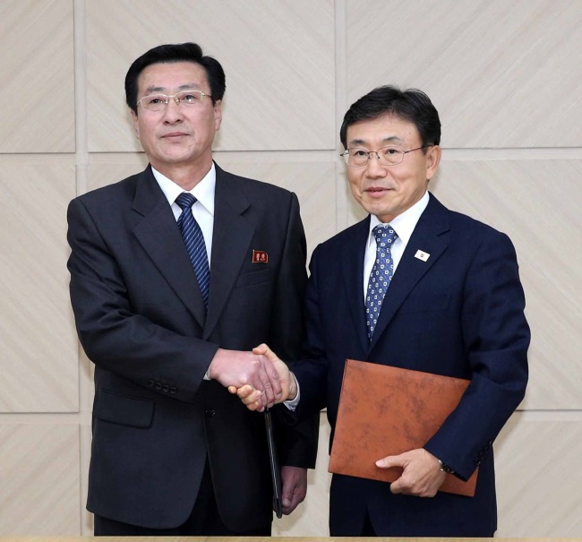Kwon Deok-cheol (right), South Korea’s Vice Health Minister, and his North Korean counterpart, Park Myong-su, pose for a photo after reaching an agreement during an inter-Korean meeting held in the North’s border town of Kaesong, Wednesday. (Yonhap)