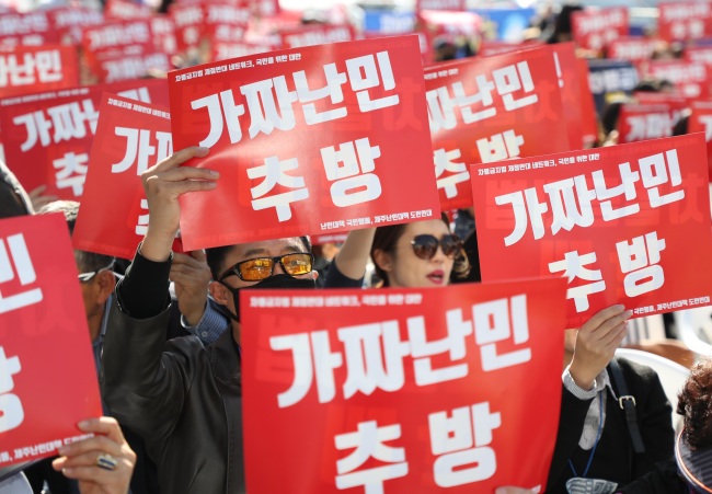 Korean participants attend a anti-refugee rally and hold a sign that says 