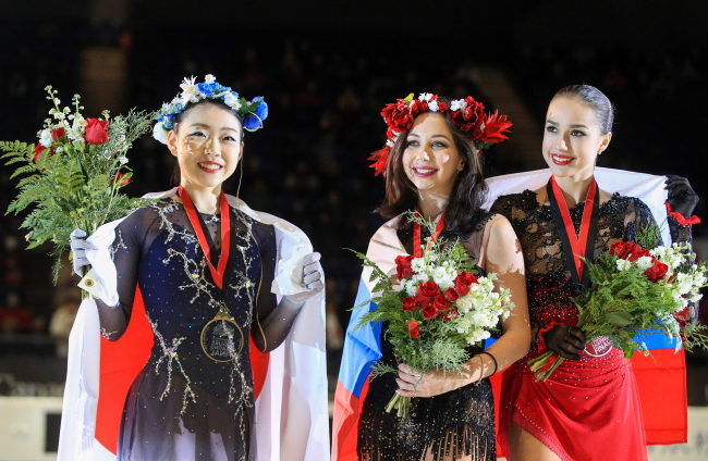 Gold medallist Rika Kihira of Japan, bronze medallist Yelizaveta Tuktamysheva of Russia, and silver medallist Alina Zagitova of Russia, from left, pose at a victory ceremony for the ladies` singles competition at the 2018/19 ISU Grand Prix of Figure Skating Final at the Doug Mitchell Thunderbird Sports Centre. (Yonhap)