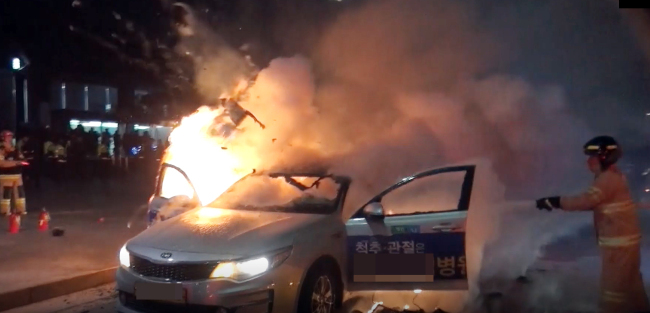 Fire fighters put off a taxi on fire after taxi driver Lim, 65, lit himself on fire earlier this month protesting to Kakao carpool service in front of Gwanghwamun Station. (Yonhap)