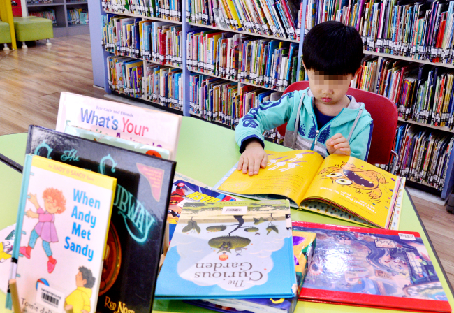 A child reads an English picture book inside Mapo English Literacy Center, a public library of English books for children in central Seoul. (Park Hyun-koo/The Korea Herald)
