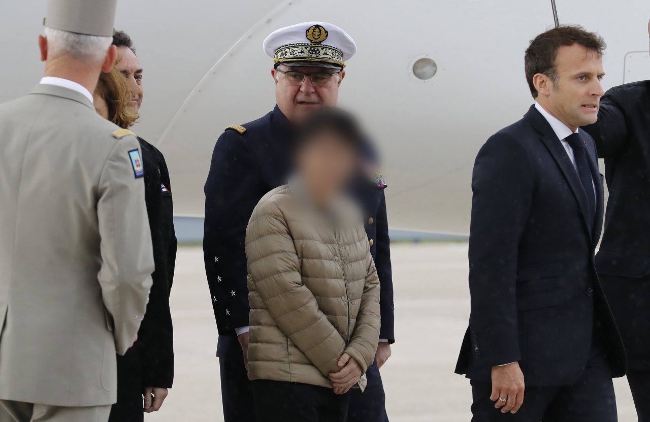 Unnamed freed South Korean hostage, left, and French President Emmanuel Macron walk on the tarmac at Villacoublay's military airport, west of Paris, France, Saturday. (Yonhap)