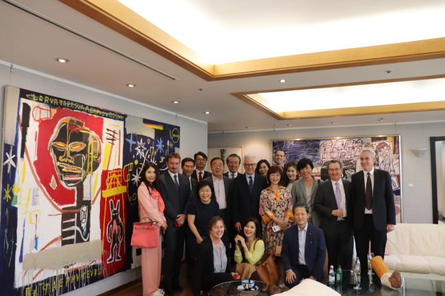 POSING WITH BASQUIAT -- Choi Jung-wha (third from left, second row), head of the Corea Image Communication Institute, Kim Young-ho (fourth from left, second row), Ilshin Spinning chairman, and H.E. Federico Failla (fifth from left, second row), Italian ambassador to Korea, pose for photos next to artist Jean-Michel Basquiat’s painting “TBT,” along with other guests at “Korea CQ, 5.4 Club,” an event hosted by CICI at the Ilshin Spinning headquarters in Yeouido, Seoul, Tuesday. (CICI)