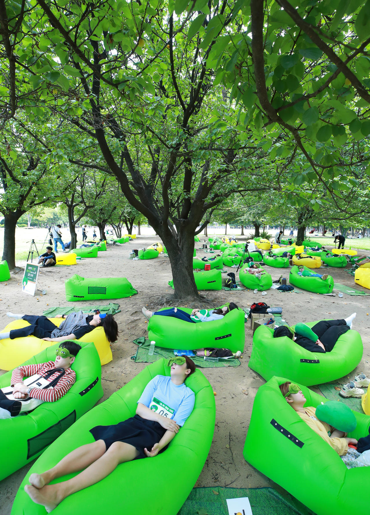 People lie down under the trees in Seoul Forest in Seoul's Seongdong district on Sunday, part of a 